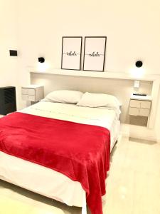 瑪斯德阿霍的住宿－Hogar Dulce Hogar，一间白色卧室,床上铺有红色毯子