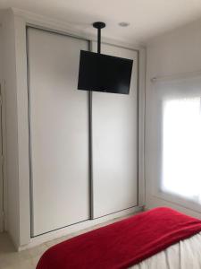 um quarto com uma porta de vidro deslizante com um cobertor vermelho em Hogar Dulce Hogar em Mar de Ajó