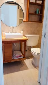 uma casa de banho com um lavatório, um WC e um espelho. em Hogar Dulce Hogar em Mar de Ajó