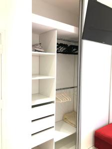 un armario con estanterías blancas en una habitación en Hogar Dulce Hogar en Mar de Ajó