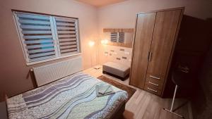 niewielka sypialnia z łóżkiem i oknem w obiekcie Apartman-Suite "Marinero" w mieście Vršac