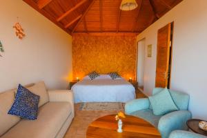 a bedroom with a bed and a couch and a table at Greenwave Ecolodge in Mirleft