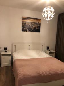 a bedroom with a white bed and a chandelier at Green 44 Central Bucharest Universitate in Bucharest
