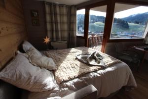 a bedroom with a bed and a large window at L'OURALOU - Vue panoramique in Les Gets