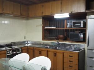 a kitchen with wooden cabinets and a sink and a stove at Yadoya Sho - Vacation STAY 13531 in Kurume