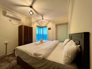 1 dormitorio con 1 cama grande con sábanas blancas en Raqeem Hotel en Wadi Musa