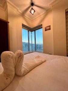 Un dormitorio con una cama con una toalla. en Raqeem Hotel, en Wadi Musa