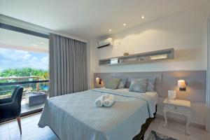 a bedroom with a bed with two towels on it at WaiWai 306 - Apê C/ Varanda Vista Mar by Carpediem in Cumbuco