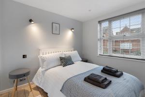 a bedroom with a bed with two towels on it at Dillywicks by Staytor Accommodation in Exeter +18 photos