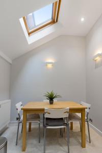 Dillywicks by Staytor Accommodation في إكسيتير: غرفة طعام مع طاولة وكراسي خشبية