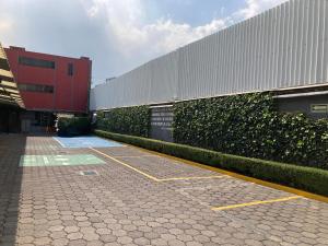 a building with a hedge next to a parking lot at HOTEL HUIPULCO in Mexico City