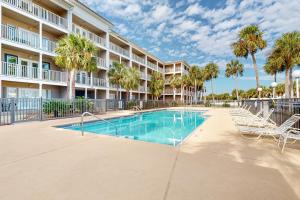 - une piscine en face d'un bâtiment avec des palmiers dans l'établissement Grand Caribbean Perdido Key 211 EAST, à Pensacola