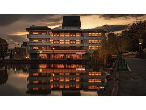 Hotel Tenpyo Naramachi - Vacation STAY 59515v في نارا: مبنى اضاءته عاكسه في الماء