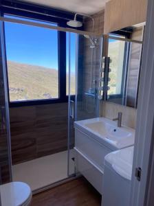 een badkamer met een wastafel, een douche en een toilet bij Ático dúplex en Monte Gorbea in Sierra Nevada