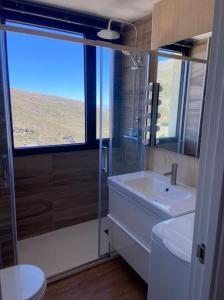 uma casa de banho com um lavatório, um chuveiro e um WC. em Ático dúplex en Monte Gorbea em Serra Nevada