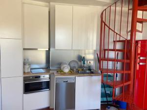 uma cozinha com armários brancos e uma escada vermelha em Ático dúplex en Monte Gorbea em Sierra Nevada