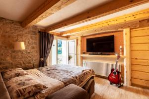 una camera con un letto e una chitarra in una stanza di Il nido del pettirosso a Enego
