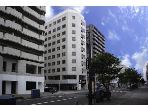 un edificio blanco alto en una calle de la ciudad en Santiago Hotel - Vacation STAY 74090v, en Hiroshima