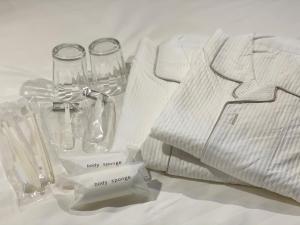 a table with a white shirt and glasses and napkins at Santiago Hotel - Vacation STAY 74090v in Hiroshima