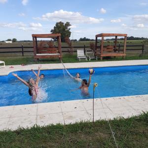 un gruppo di persone che giocano in piscina di Cabañas El Encuentro Lobos a Salvador María