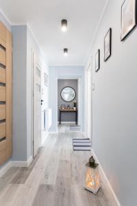 um corredor vazio com paredes brancas e pisos de madeira em Rybacka 48 - Twoje miejsce wypoczynku, domki, pokoje, apartamenty em Jantar