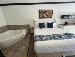 - une chambre avec un lit et une baignoire à côté d'un lit sidx sidx dans l'établissement Monastery Hotel, à Saint-Jean