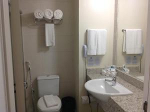 a bathroom with a sink and a toilet and a mirror at Holiday Inn Express Belem Ananindeua, an IHG Hotel in Belém