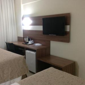a hotel room with a desk with a television on the wall at Holiday Inn Express Belem Ananindeua, an IHG Hotel in Belém