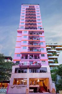 un edificio alto de color rosa con balcones. en Golden Rain 2 Hotel, en Nha Trang