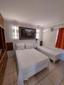 een hotelkamer met 2 bedden en een raam bij dirioma fiori 410 descanso, paz, alegria e muita diversão em águas termais in Caldas Novas