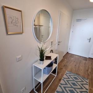 a bathroom with a mirror and a table with a plant at Ferienwohnung Amelie in Sattendorf