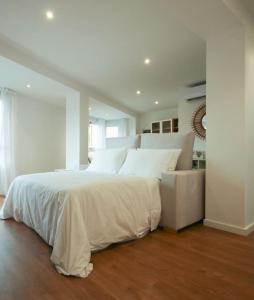 1 dormitorio con 1 cama blanca grande y 1 colchón blanco en LC Apartaments Center, en Castellón de la Plana