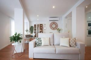 una sala de estar con un sofá blanco con almohadas en LC Apartaments Center, en Castellón de la Plana
