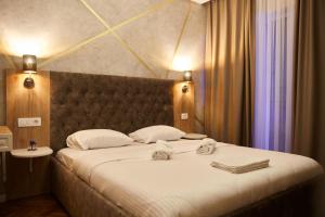 Amico Hotel في بريشتيني: غرفة نوم بسرير كبير عليها منشفتين