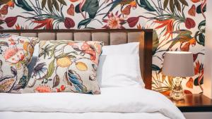a bedroom with a bed with a floral wallpaper at The Avonmore Olympia in London