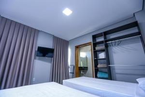 a hotel room with two beds and a mirror at Vila Nóbrega Residencial in Foz do Iguaçu +26 photos