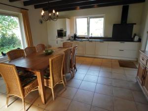 cocina con mesa de madera y sillas en Holiday home with view over the meadows en Kibbelveen