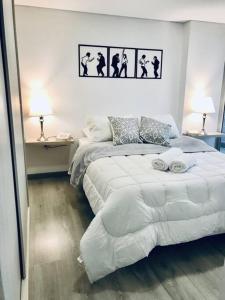 ein weißes Schlafzimmer mit 2 Betten und 2 Lampen in der Unterkunft Acogedor y moderno loft para descanso in Paipa