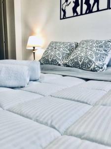 2 camas blancas en una habitación con lámpara en Acogedor y moderno loft para descanso, en Paipa