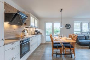 a kitchen and dining room with a table and chairs at Getidenhus Emma in Sankt Peter-Ording