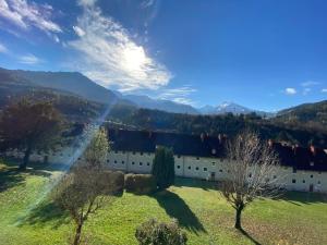 un edificio en un campo con montañas en el fondo en Eisenerz Stefan Apartment / Ferien Wohnung, en Eisenerz