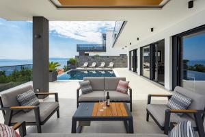 um pátio exterior com uma mesa e cadeiras e uma piscina em Villa Titanium em Opatija