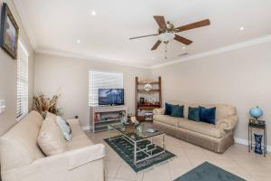 uma sala de estar com dois sofás e uma televisão em OCEAN VACATION BREEZE em Lantana
