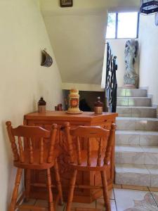 a room with two chairs and a table and stairs at Casa de campo Mi muchachito in Pátzcuaro