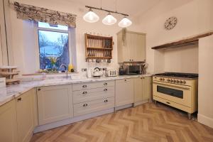 a large kitchen with white cabinets and a window at The Haven in Llandeilo