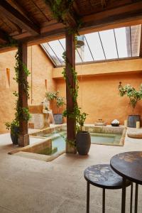 a courtyard with a pool with tables and plants at Hacienda el Potrero - Un lugar para siempre recordar in Suesca