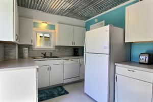 ポート・アランサスにある4 Palmsの白いキャビネットと白い冷蔵庫のあるキッチン