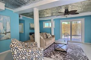 ポート・アランサスにある4 Palmsのソファと天井ファンのあるリビングルーム
