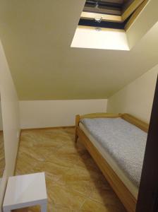 a small bedroom with a bed and a skylight at Apartment parking loft Akaciju in Vilnius +2 photos