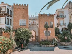 a brick building with a palm tree in front of it at ¡Impactante apartamento a cero linea de mar! in Tarragona